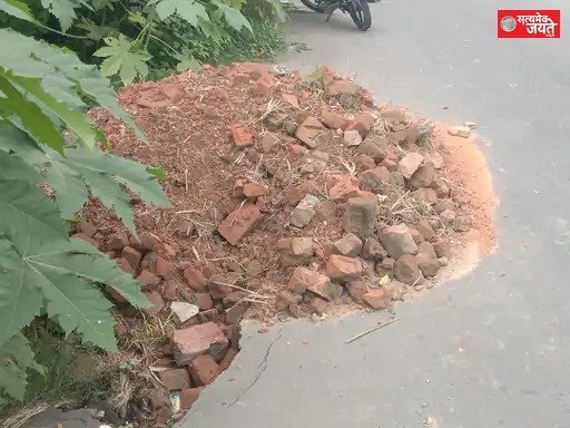 तेजगढ़ में बारिश से धंसी सड़क, ईंट के टुकड़ों से बढ़ा हादसे का खतरा