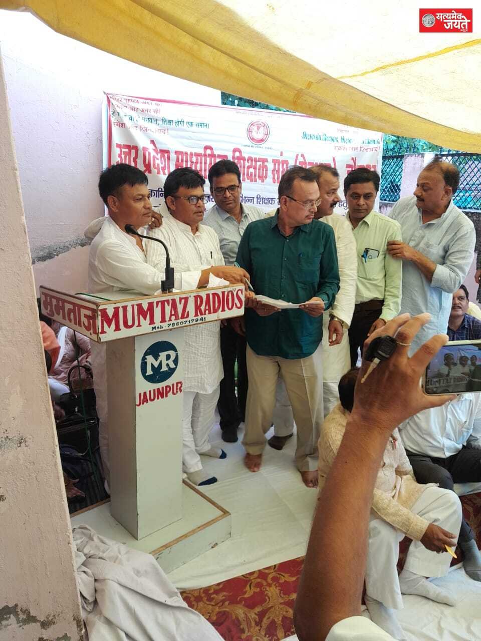 जौनपुर ‘क्रान्ति‘दिवस’’ के अवसर पर शिक्षकों की विभिन्न समस्याओं को लेकर उ0प्र0 माध्यमिक शिक्षक संघ ’सेवारत’ के प्रदेशीय नेतृत्व के आह्वाहन पर जिला विद्यालय निरीक्षक कार्यालय पर जनपदीय कार्यकारिणी एवं शिक्षक साथियों द्वारा विशाल धरना दिया गया। इसके पूर्व धरने को लेकर जिला प्रशासन और शिक्षक नेताओं तीखी नोक-झोक हुई। जिला प्रशासन द्वारा धरना स्थल पर लगाये गये टेन्ट और कुर्सियों सहित अन्य सामान को बल पूर्वक हटवा दिया गया।उ0प्र0 माध्यमिक शिक्षक संघ (सेवारत) घोर निन्दा करता है और लोक तांत्रिक एवं शान्तिपूर्ण धरने की अनुमति न देकर अपने तानाशाही का परिचय दिया अथवा वह संगठन की संख्या बल से भयभीत हो गया है। उक्त बाते कहते हुए उ0प्र0 माध्यमिक शिक्षक संघ ‘सेवारत’ के प्रदेश अध्यक्ष रमेश सिंह ने कहा कि हम अपनी मांगों को मनवाने के लिए और जिला प्रशासन की तानाशाही का विरोध करने के लिए प्रतिबद्ध हैं। पुरानी पेंशन बहाली, कैशलेश चिकित्सा सुविधा, एनपीएस के अन्तरण, परिषदीय परीक्षा एवं मूल्यांकन के बकाये पारिश्रमिक के भुगतान, चयन वेतनमान/प्रोन्नति वेतनमान, आनलाइन स्थानान्तरण से आये हुये शिक्षकों/प्रधानाचार्यो का कार्यभार ग्रहण आदि को लेकर जिला विद्यालय निरीक्षक कार्यालय को आगाह किया जा रहा है कि वे अपनी आदत बदलें।शिक्षकों की समस्याओं का समाधान करें। अन्यथा सेवारत संगठन मजबूर होकर जिला विद्यालय निरीक्षक कार्यालय में ताला बन्द कर देगा।